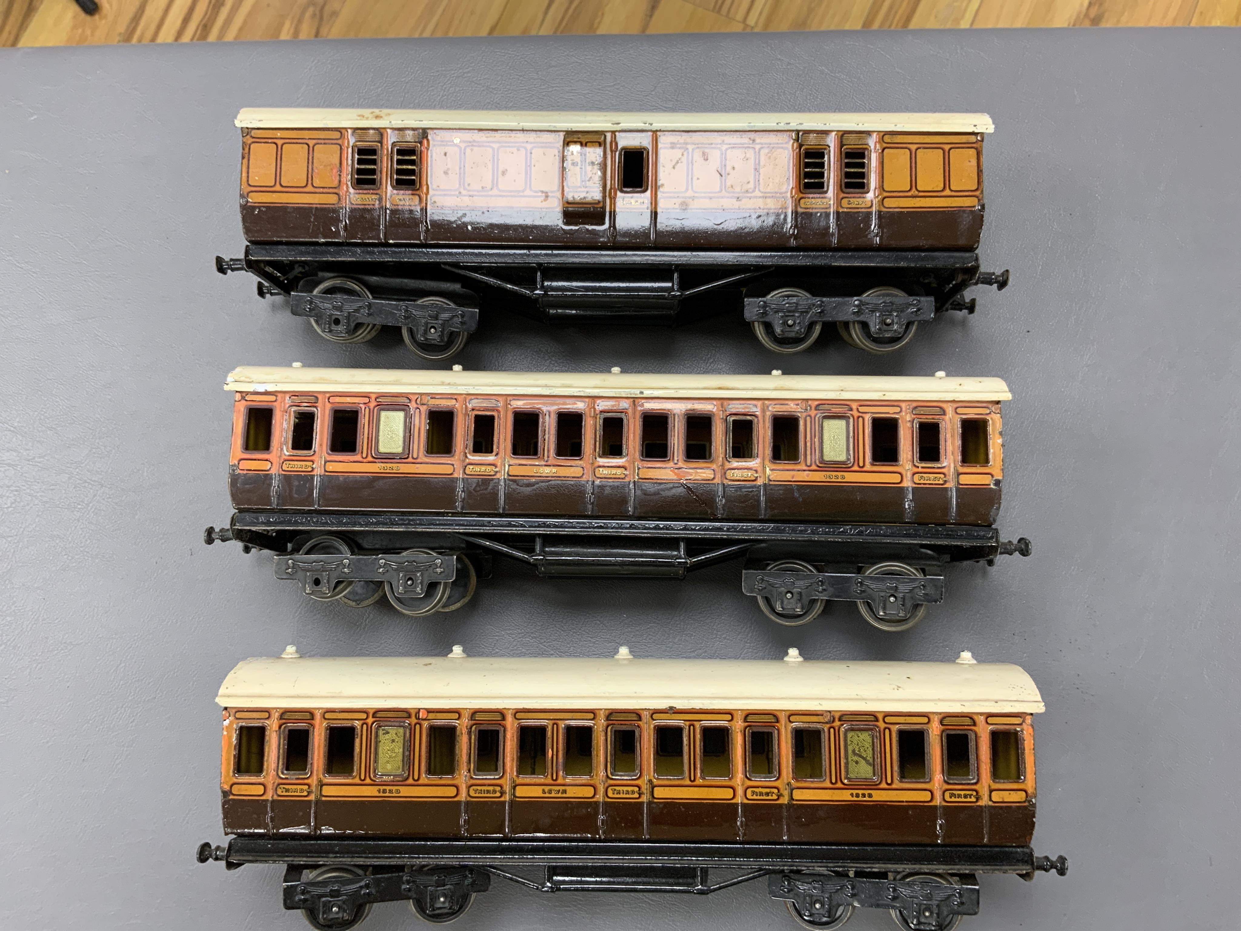 Three Carette for Bassett-Lowke 0 gauge railway 1921 series tinplate LSWR bogie coaches fitted with Bing couplings; two First Third Composite coaches, both 1328, and a full brake van, 133, all in salmon and chocolate liv